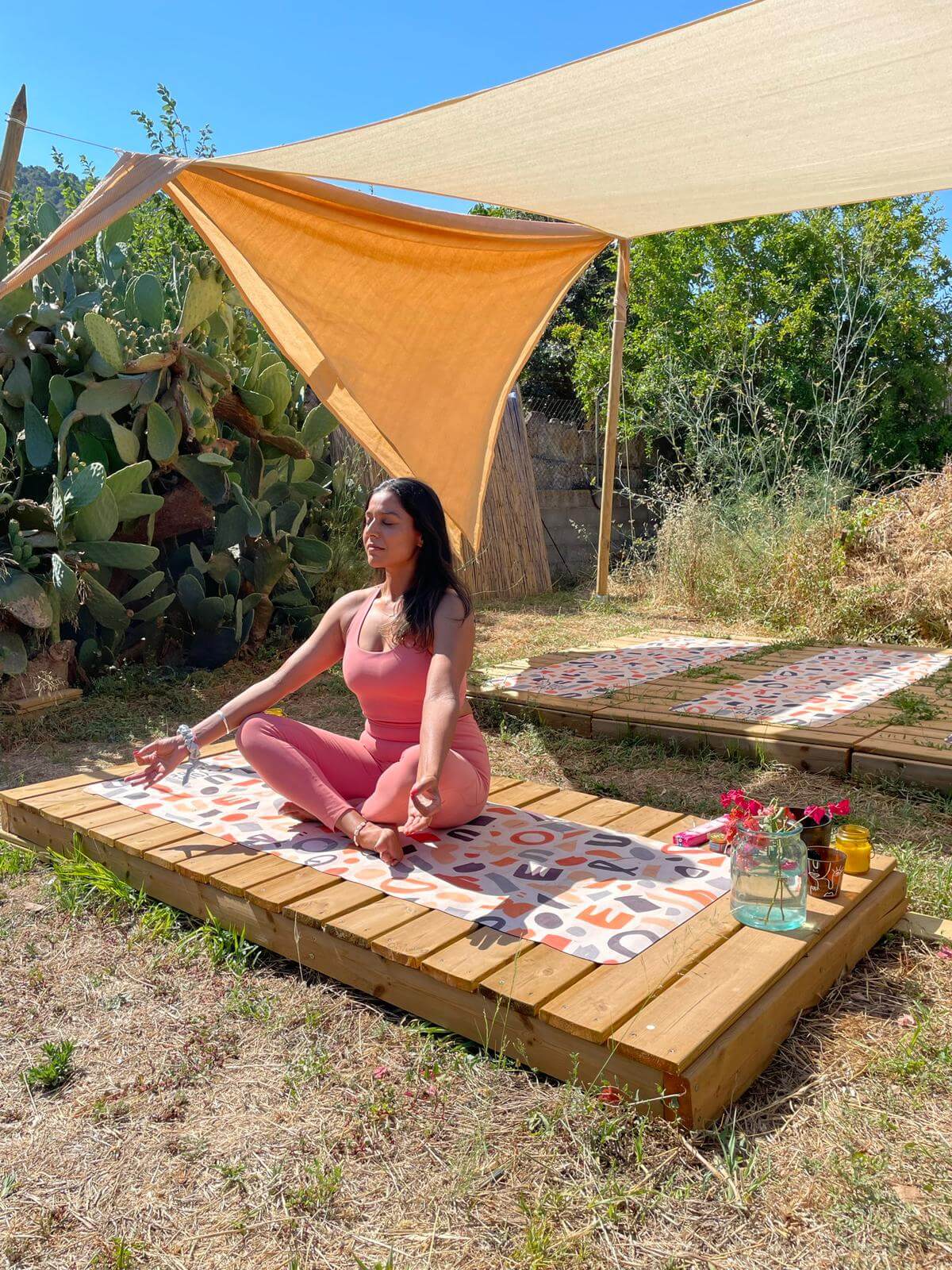 Amy Singh Yoga sat in a mudra on the beach - LGBTQ Wellness